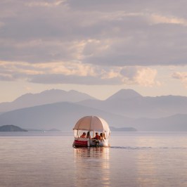 a boat on a body of water with a mountain in the background
