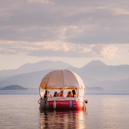 a boat on a body of water with a mountain in the background
