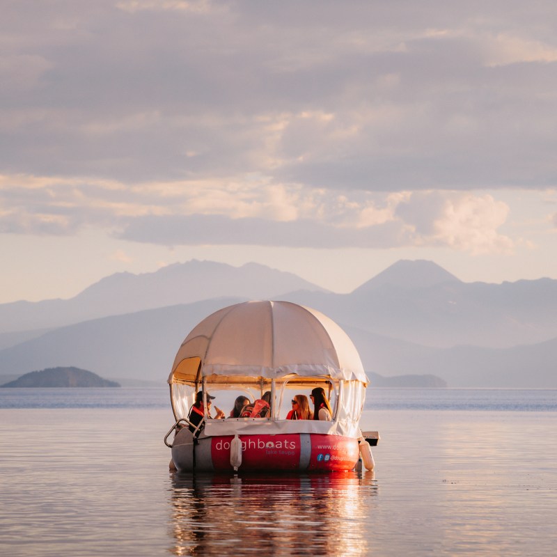 a boat on a body of water with a mountain in the background