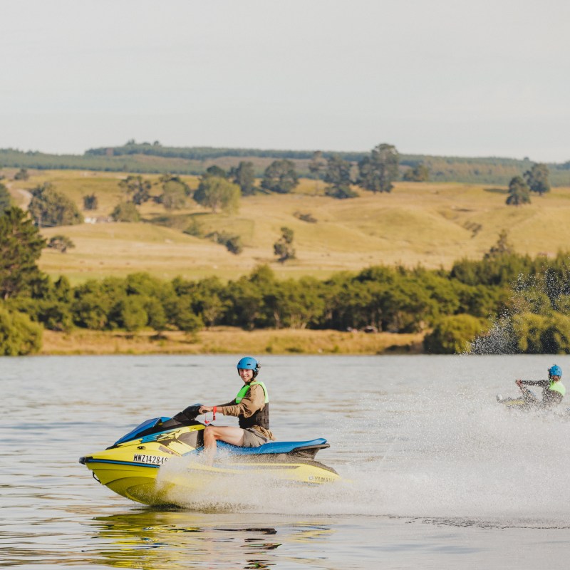a group of people riding on the back of a boat in the water